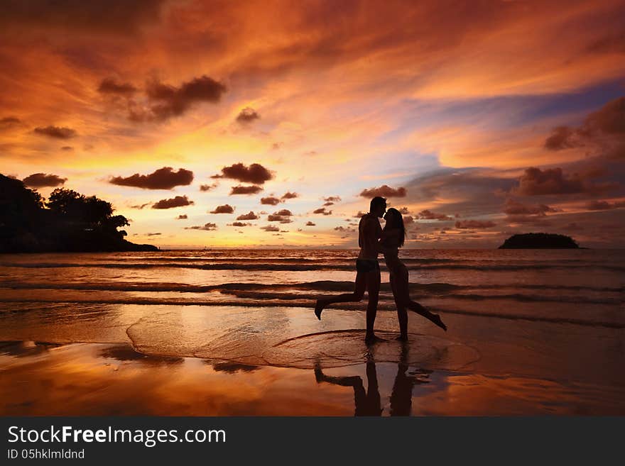 Silhouettes of lovers on a background of a sunset