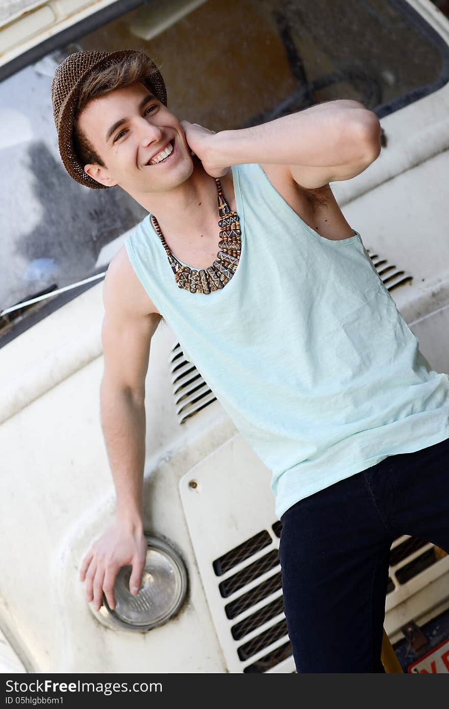 Young handsome man with an old van wearing sun hat