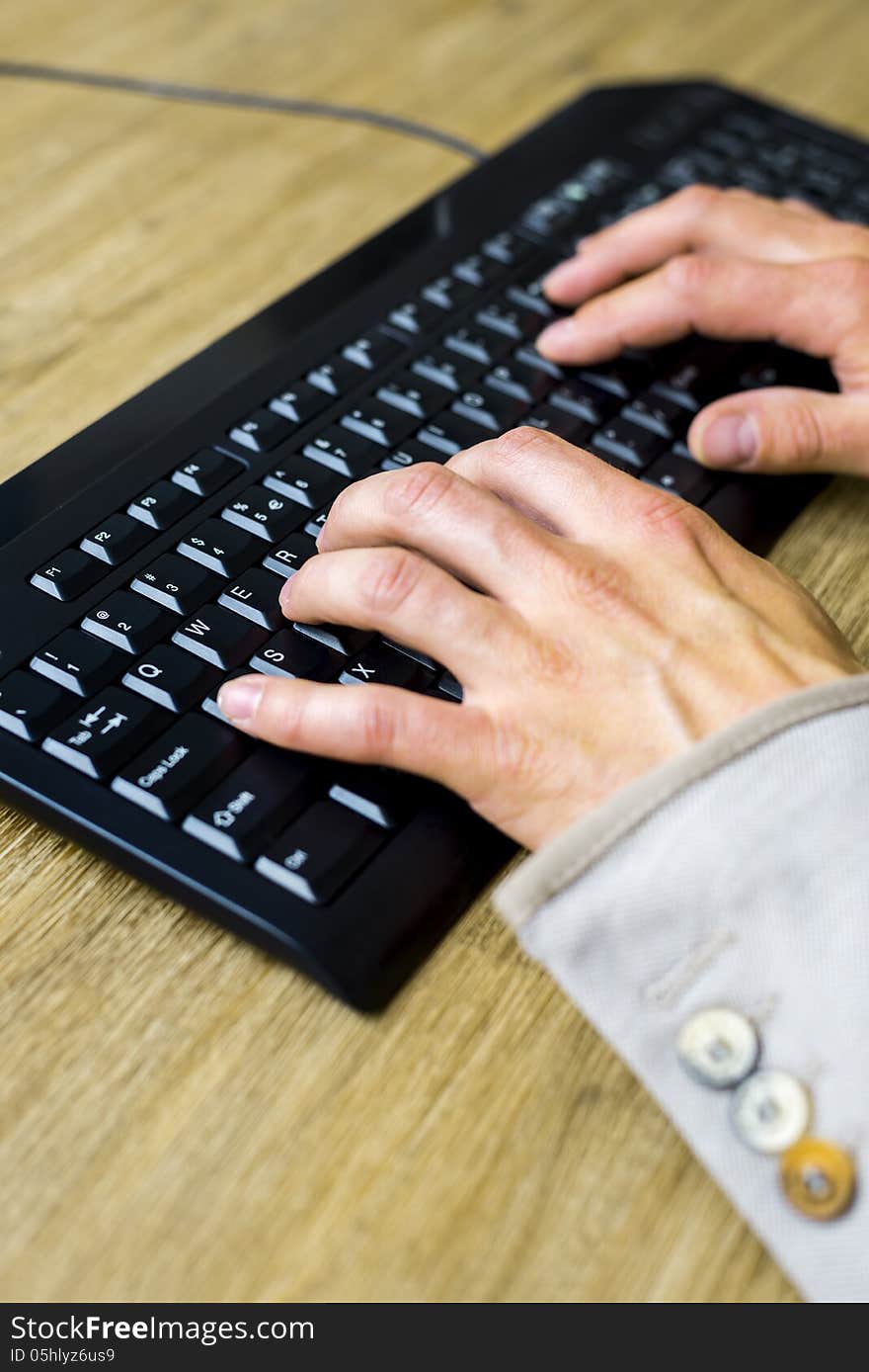 Hands typing on a black keyboard, shallow depth of field. Hands typing on a black keyboard, shallow depth of field.