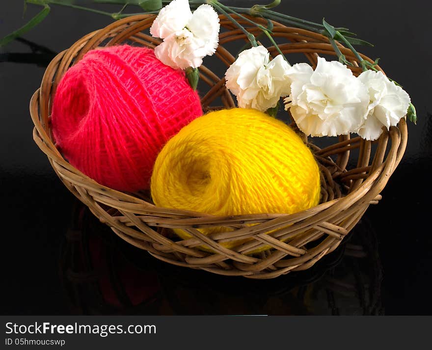 Skein of yarn in a wicker basket on a black background