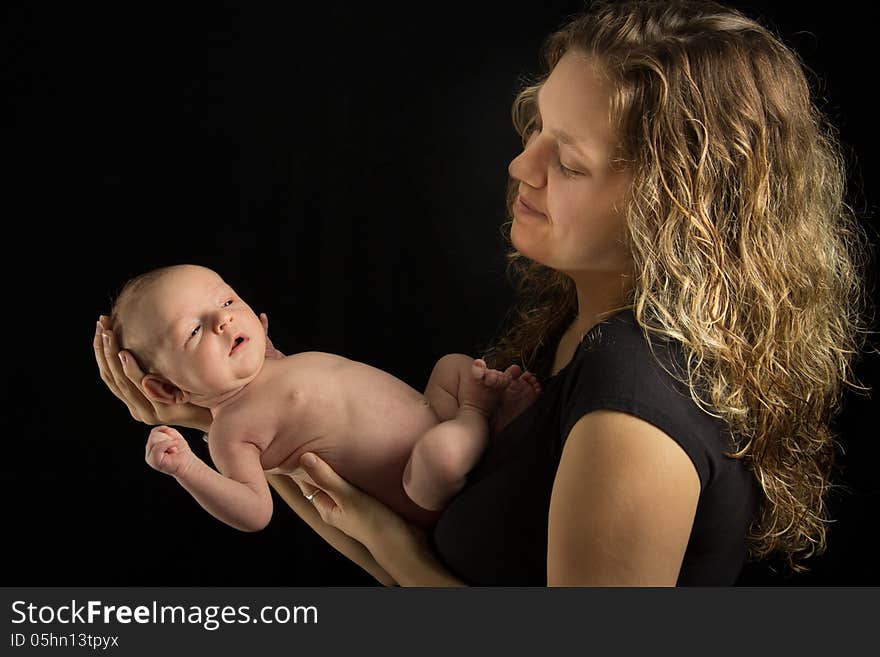 Mother holding her baby on black background. Mother holding her baby on black background