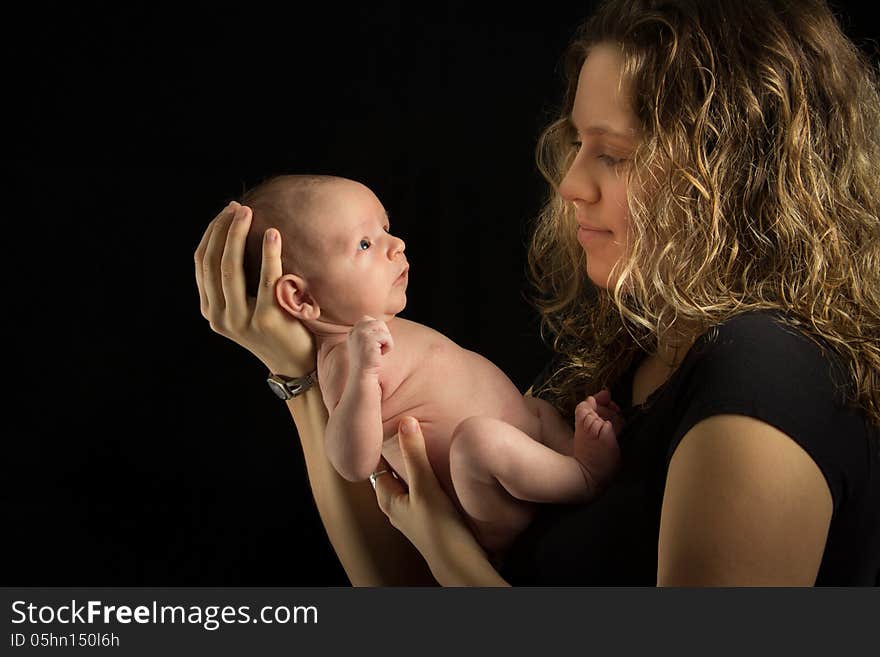 Mother holding her baby on black background. Mother holding her baby on black background