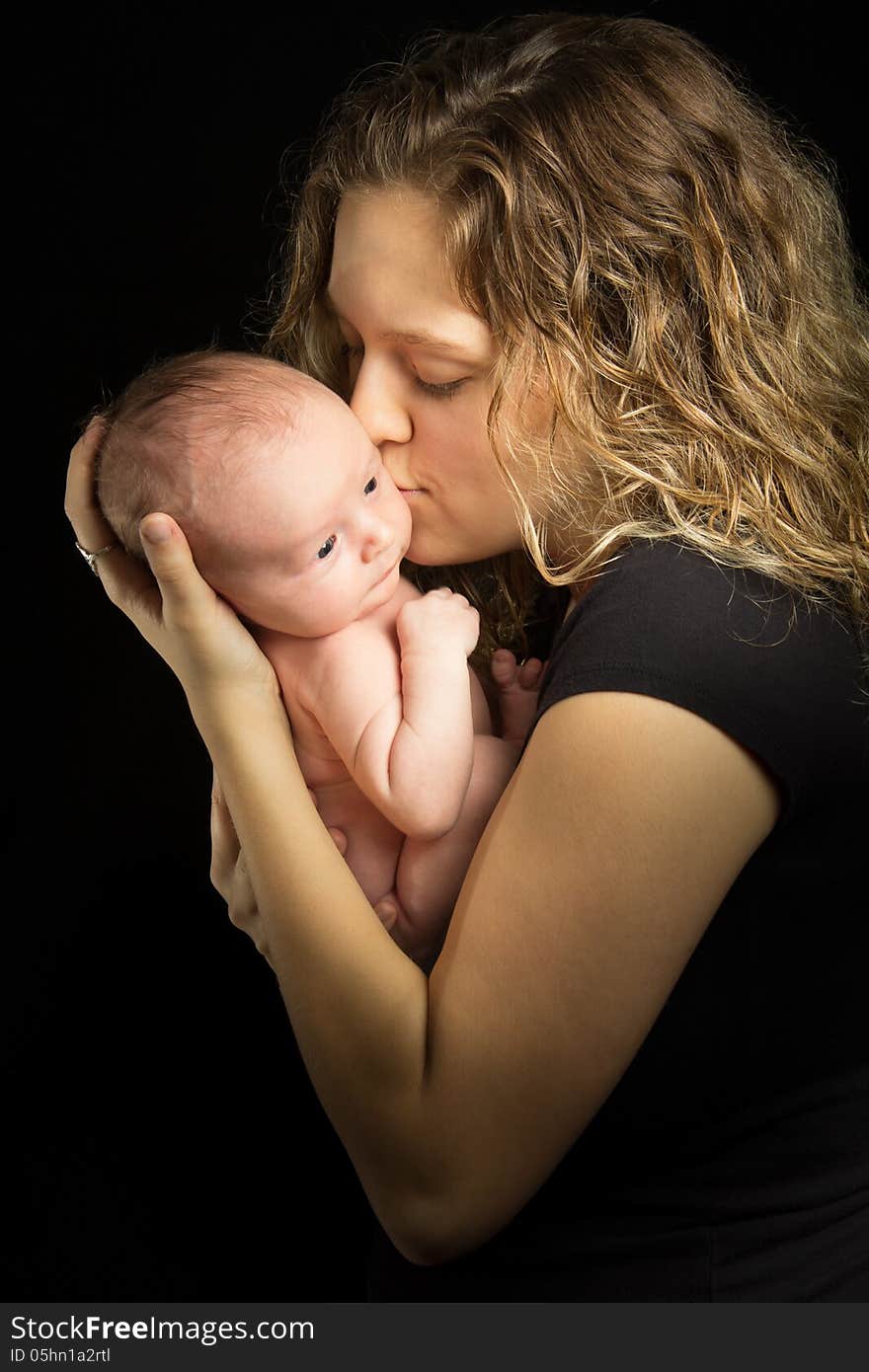 Mother holding her baby on black background. Mother holding her baby on black background