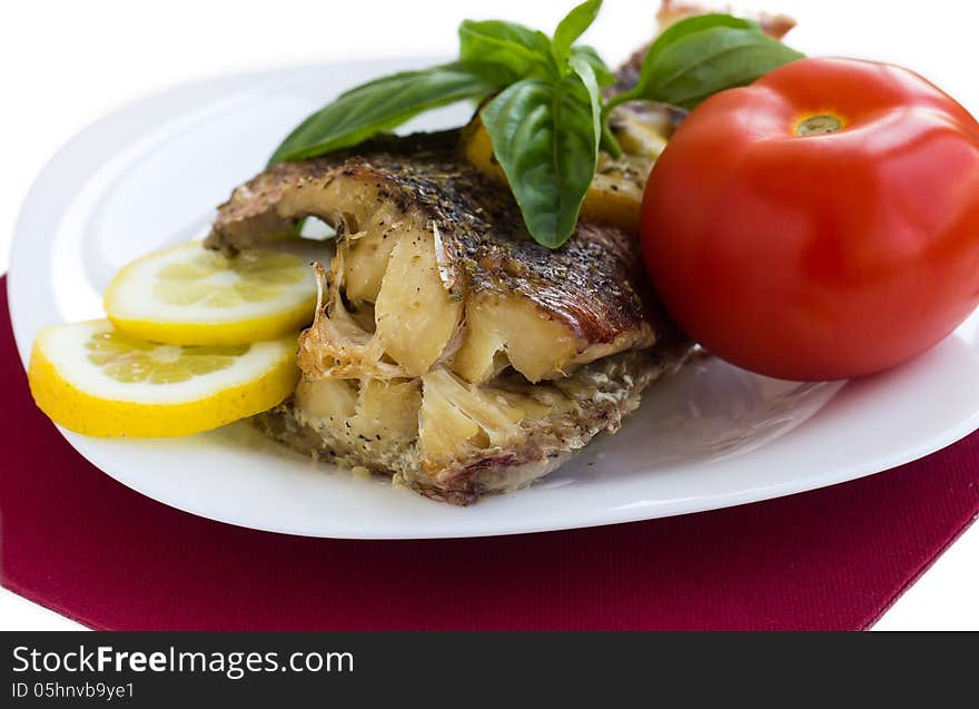 Served grilled fish with lemon and basil with tomato macro