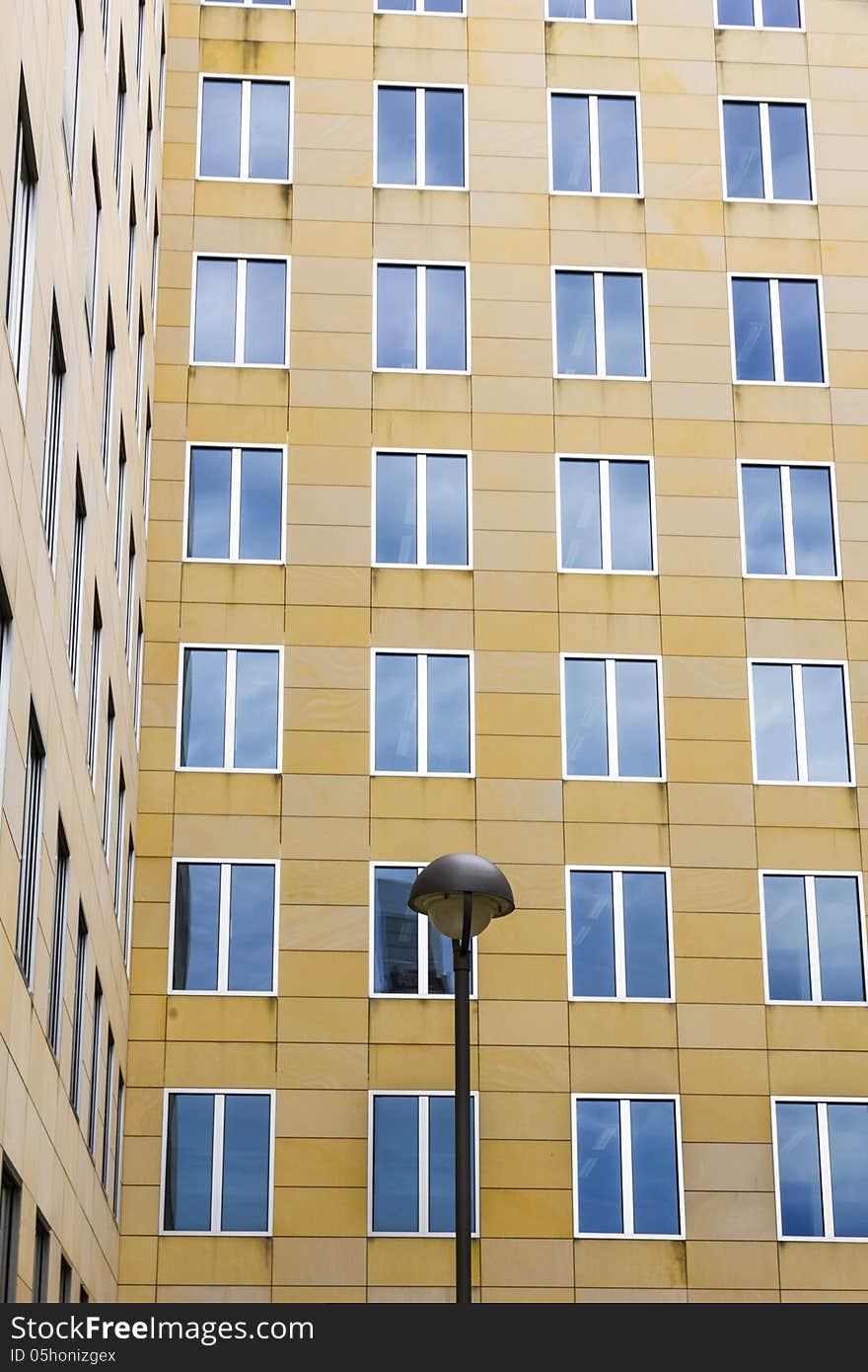 Facade with blue mirroring windows and a street-light in front