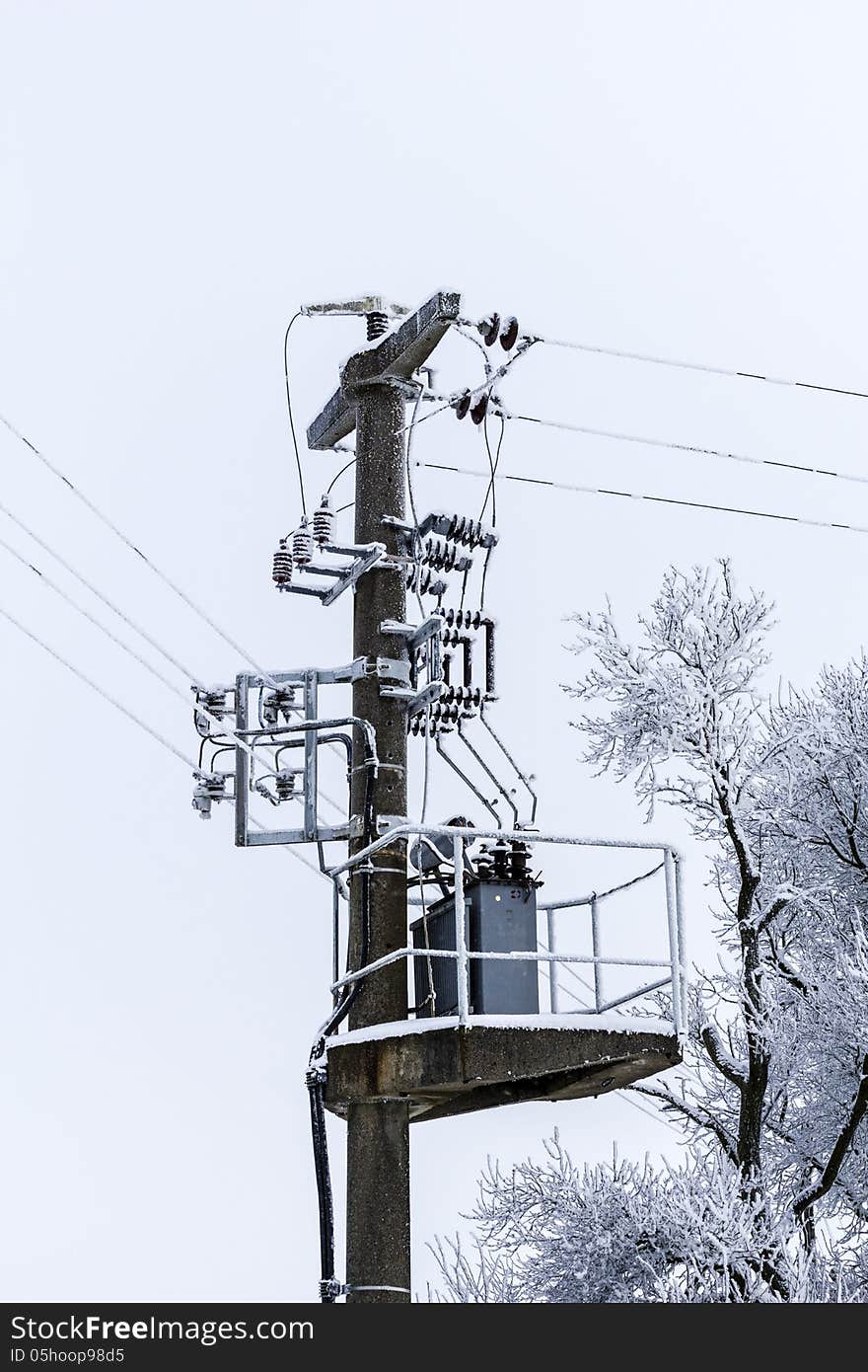 Old concrete power-line with transformer and winter-tree