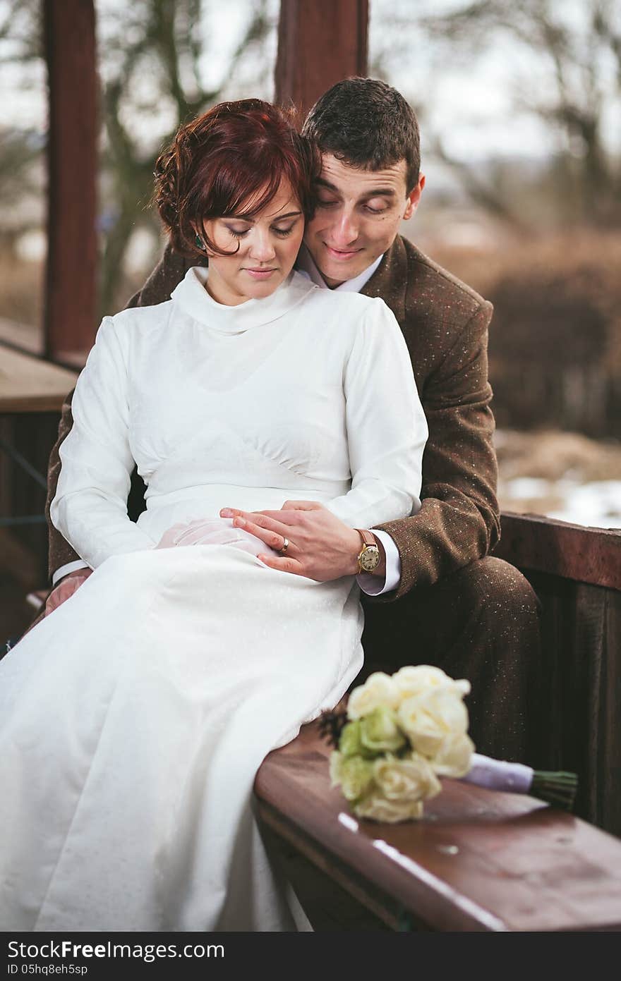 Couple of bride and groom sitting together holding hands. Couple of bride and groom sitting together holding hands.