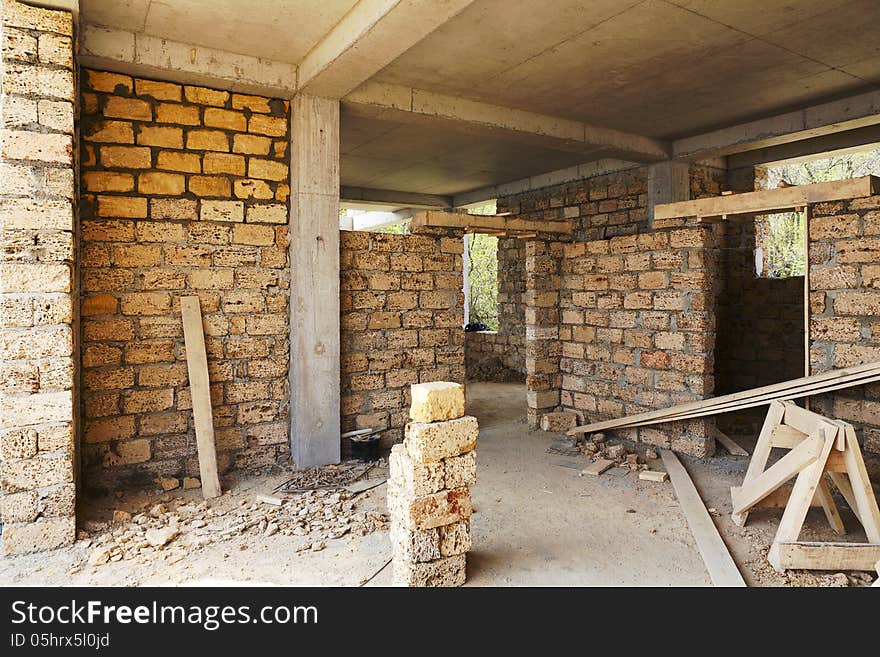 Building house of concrete frame with walls from shell rock