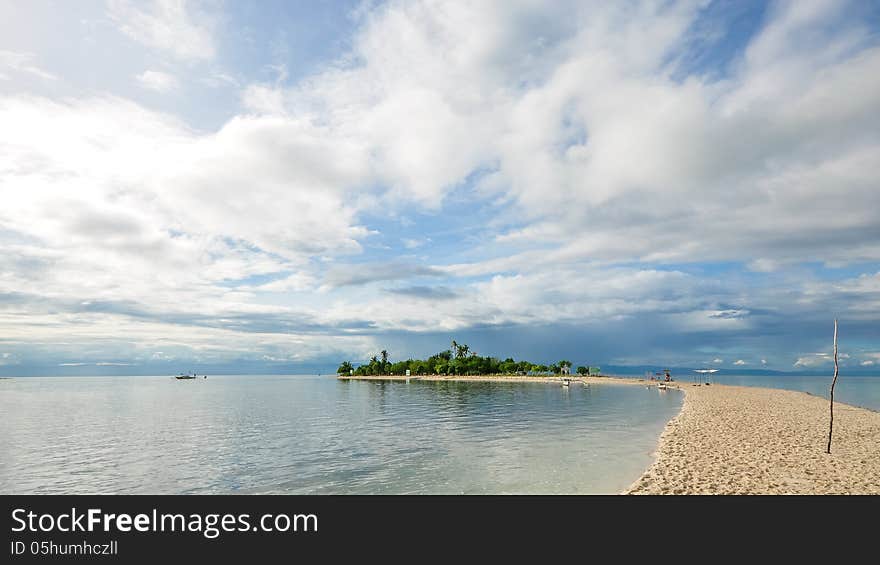 Beautiful small tropical island under the sky, the narrow white sand beach stretches like a curving line, one of the most famous travel destinations in local. Shot on Virgin Island, Cebu, Philippines, known to many locals as the “hidden oasis”.