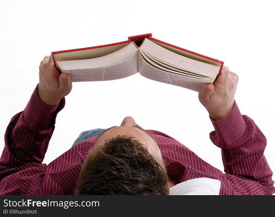 Young man lying down reading a book on bed. Young man lying down reading a book on bed.