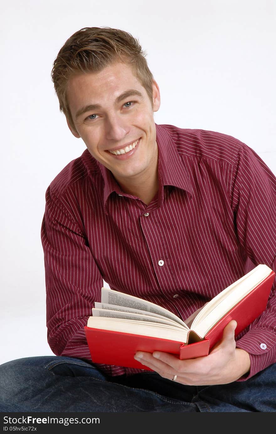 Happy young man holding and reading a book. Happy young man holding and reading a book.