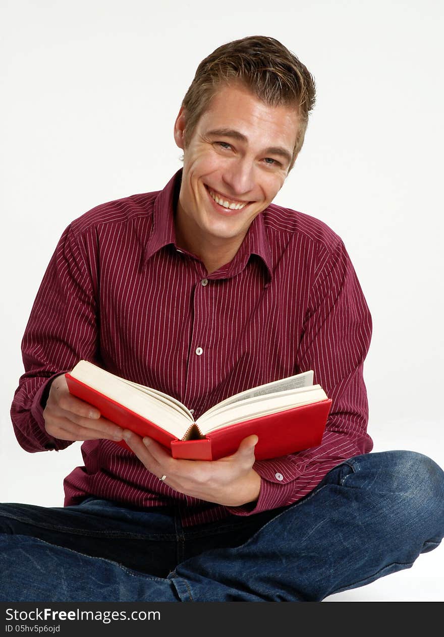 Happy young man holding and reading a book. Happy young man holding and reading a book.