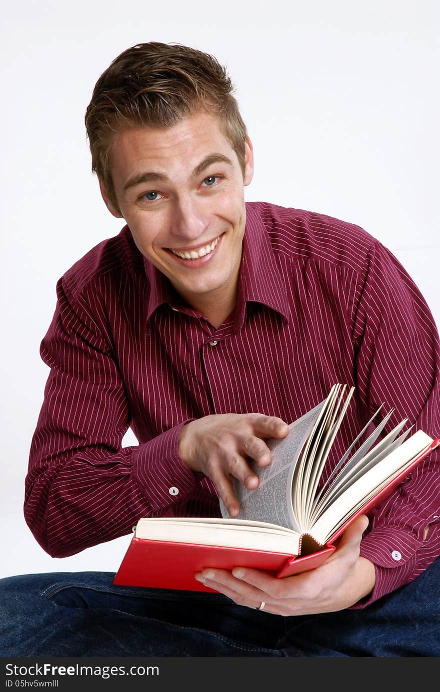 Happy young man holding and reading a book. Happy young man holding and reading a book.