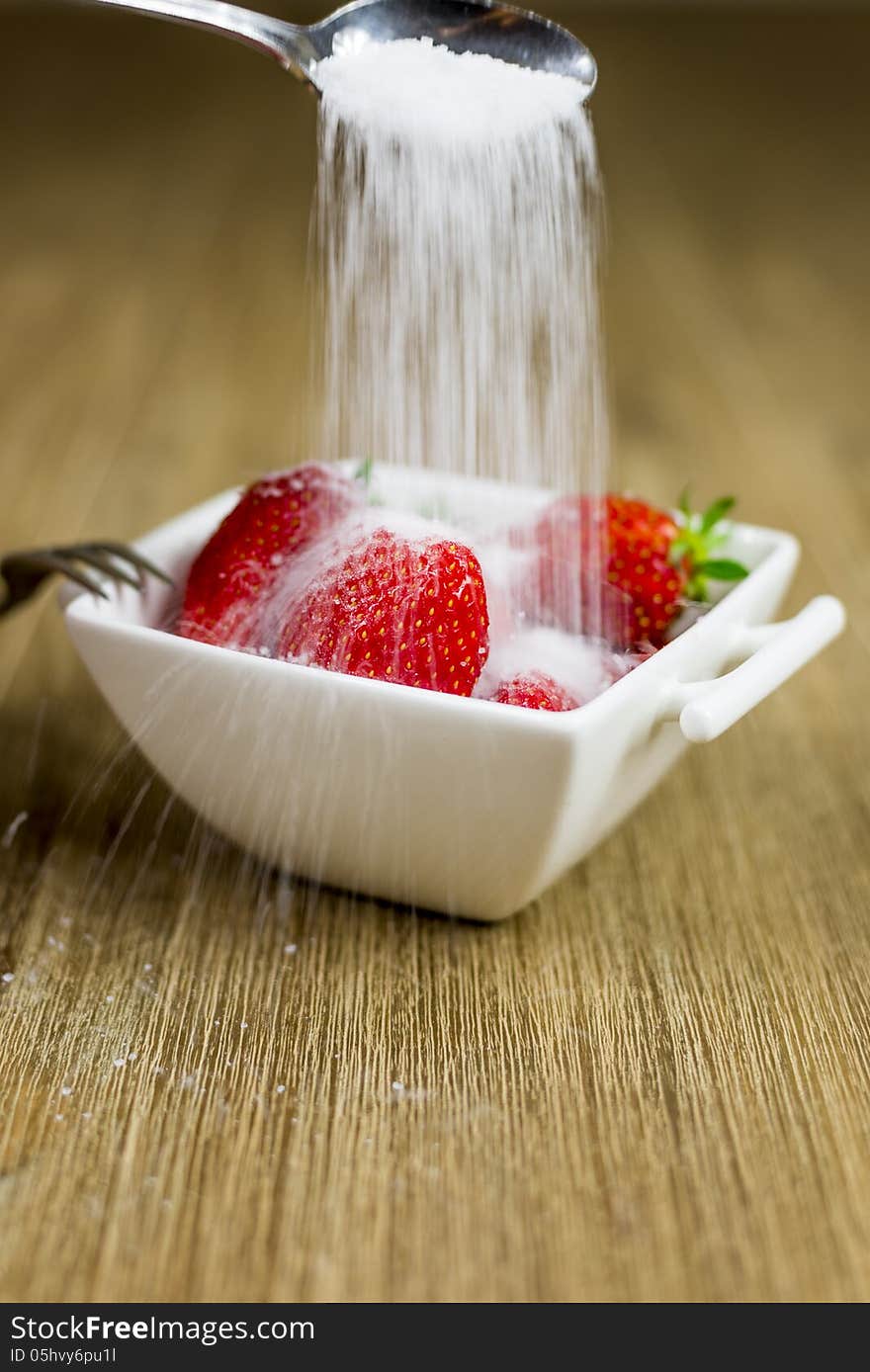 Sugar being poured over strawberries. motion blur. Sugar being poured over strawberries. motion blur