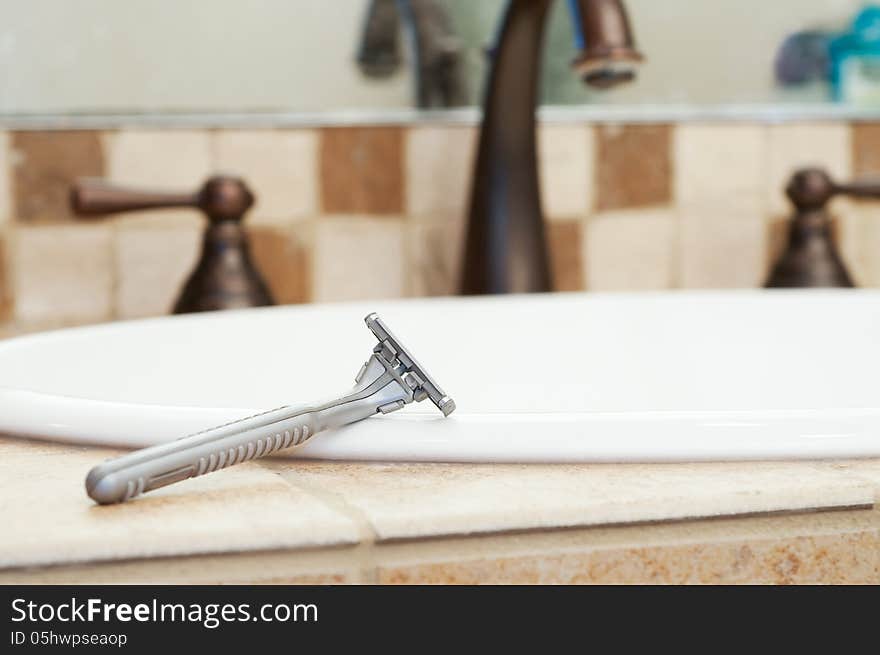 Razor Resting on Edge of Sink in Bathroom