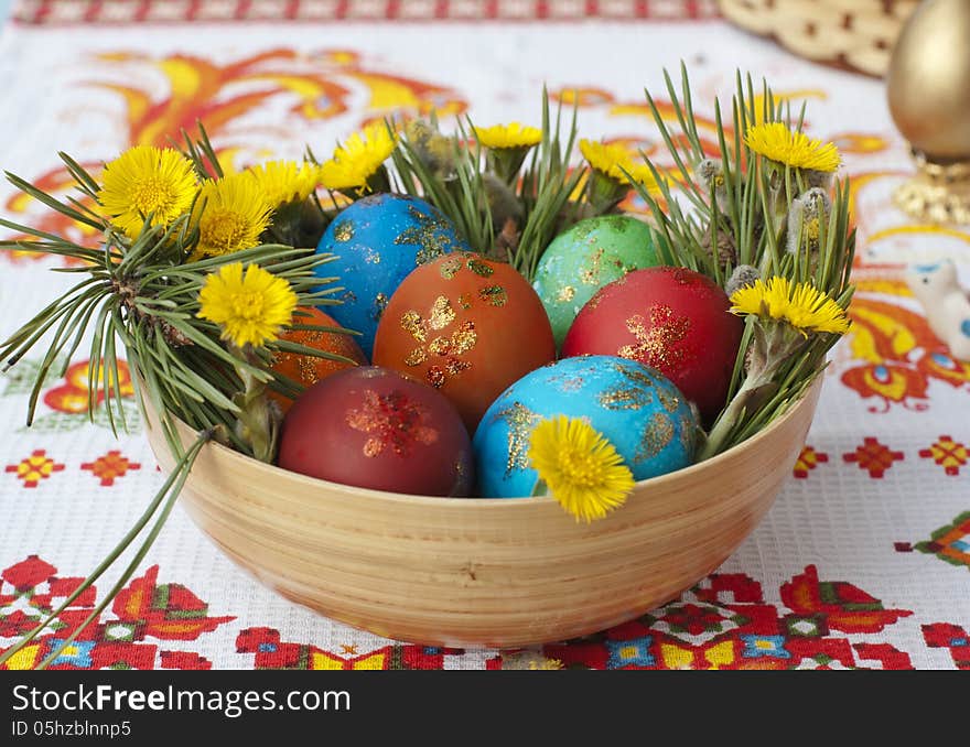 Colored small eggs in a basket by Easter