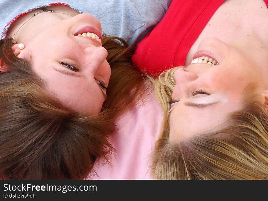 Two beautiful young women friends sharing on bed. Two beautiful young women friends sharing on bed