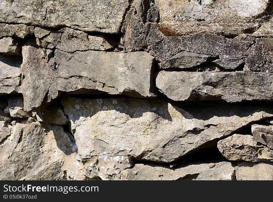 Old Stone wall with shadows and concret