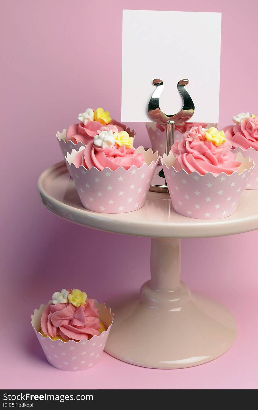 Beautiful pink decorated cupcakes on pink cake stand for birthday, wedding or female special event occasion, with blank card for your text here. Beautiful pink decorated cupcakes on pink cake stand for birthday, wedding or female special event occasion, with blank card for your text here.