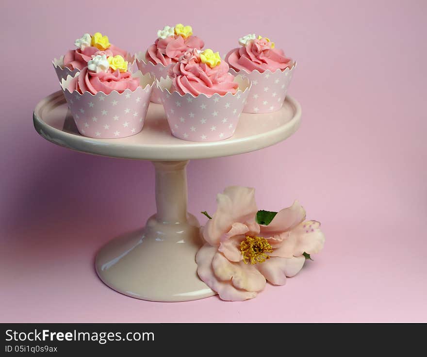 Beautiful pink decorated cupcakes on pink cake stand for birthday, wedding or female special event occasion,with pink flower. Beautiful pink decorated cupcakes on pink cake stand for birthday, wedding or female special event occasion,with pink flower.