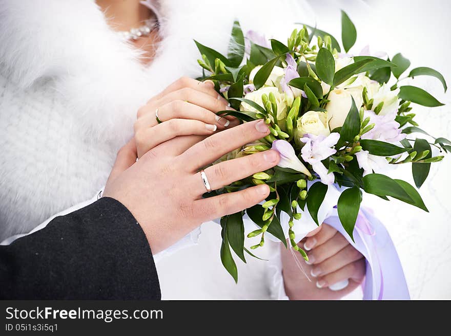 Hands with wedding gold rings and flowers