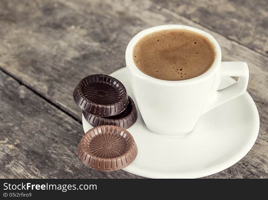 Chocolate bars and coffee cup on old wooden table. Chocolate bars and coffee cup on old wooden table