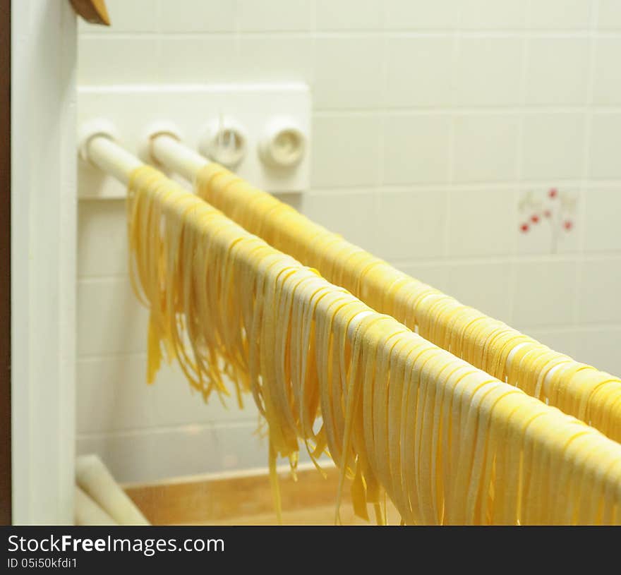 Fresh made fettuccine pasta drying on a rack. Fresh made fettuccine pasta drying on a rack