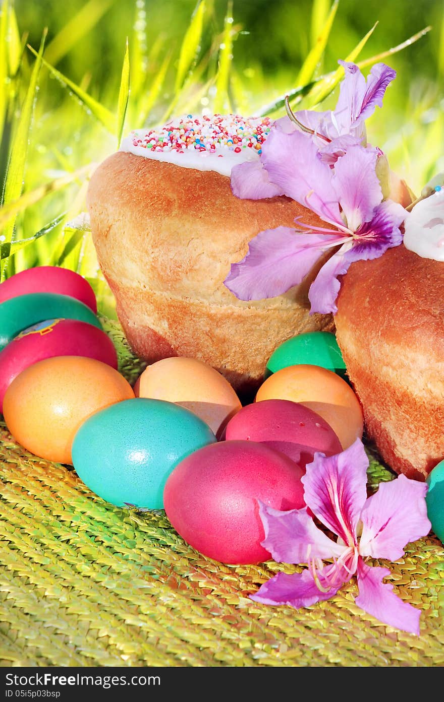 Freshly baked Easter cakes and painted eggs on the background of blurred grass. Freshly baked Easter cakes and painted eggs on the background of blurred grass