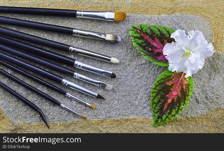 Still life of brush setting with white flower on stone. Still life of brush setting with white flower on stone