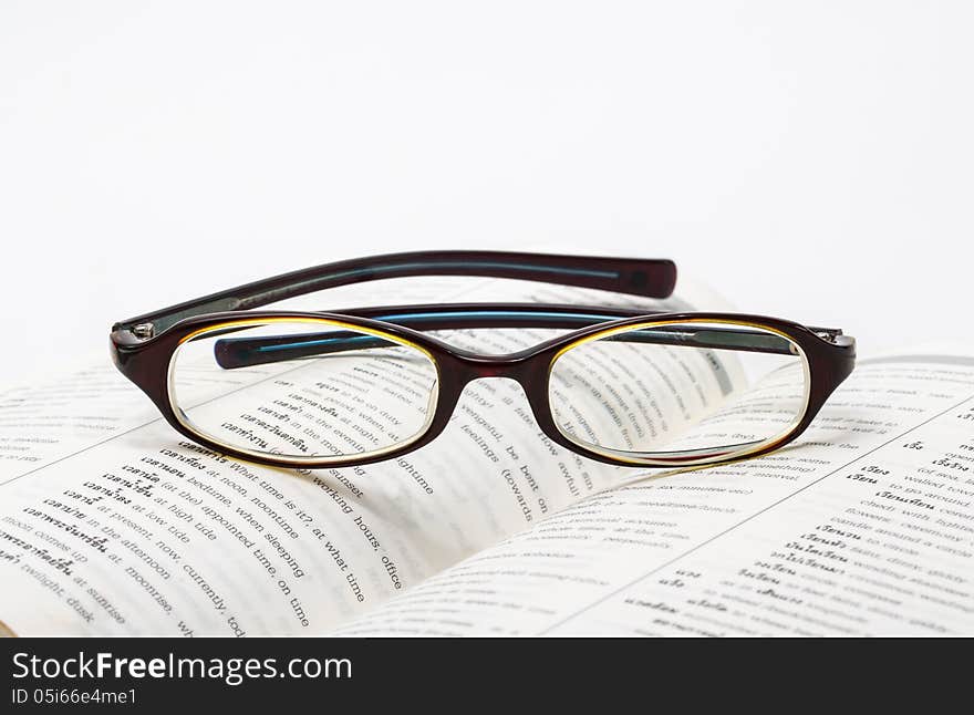 Glasses on Dictionary book opened.