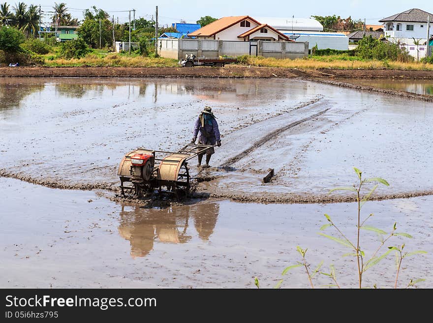 Thai farmer working with a handheld motor plow. Thai farmer working with a handheld motor plow.