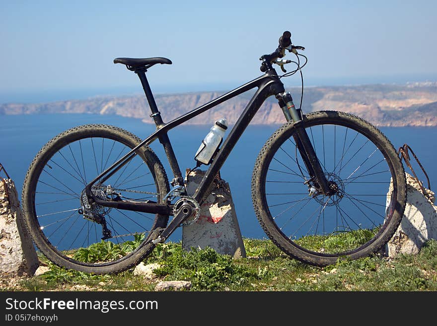 Biking on the edge of a cliff on the background of the mountains and the sea. Biking on the edge of a cliff on the background of the mountains and the sea