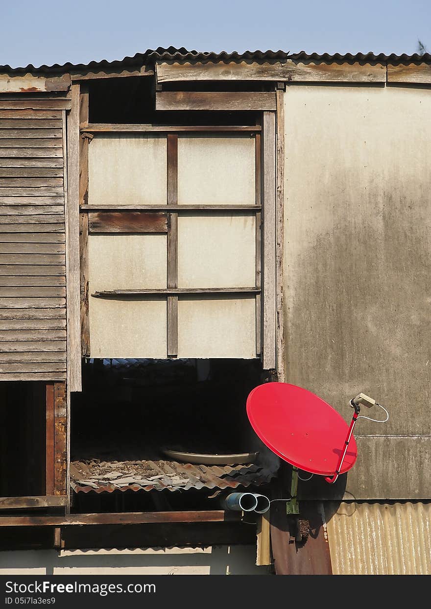 Part of abandoned house and red dish in sunny day. Part of abandoned house and red dish in sunny day