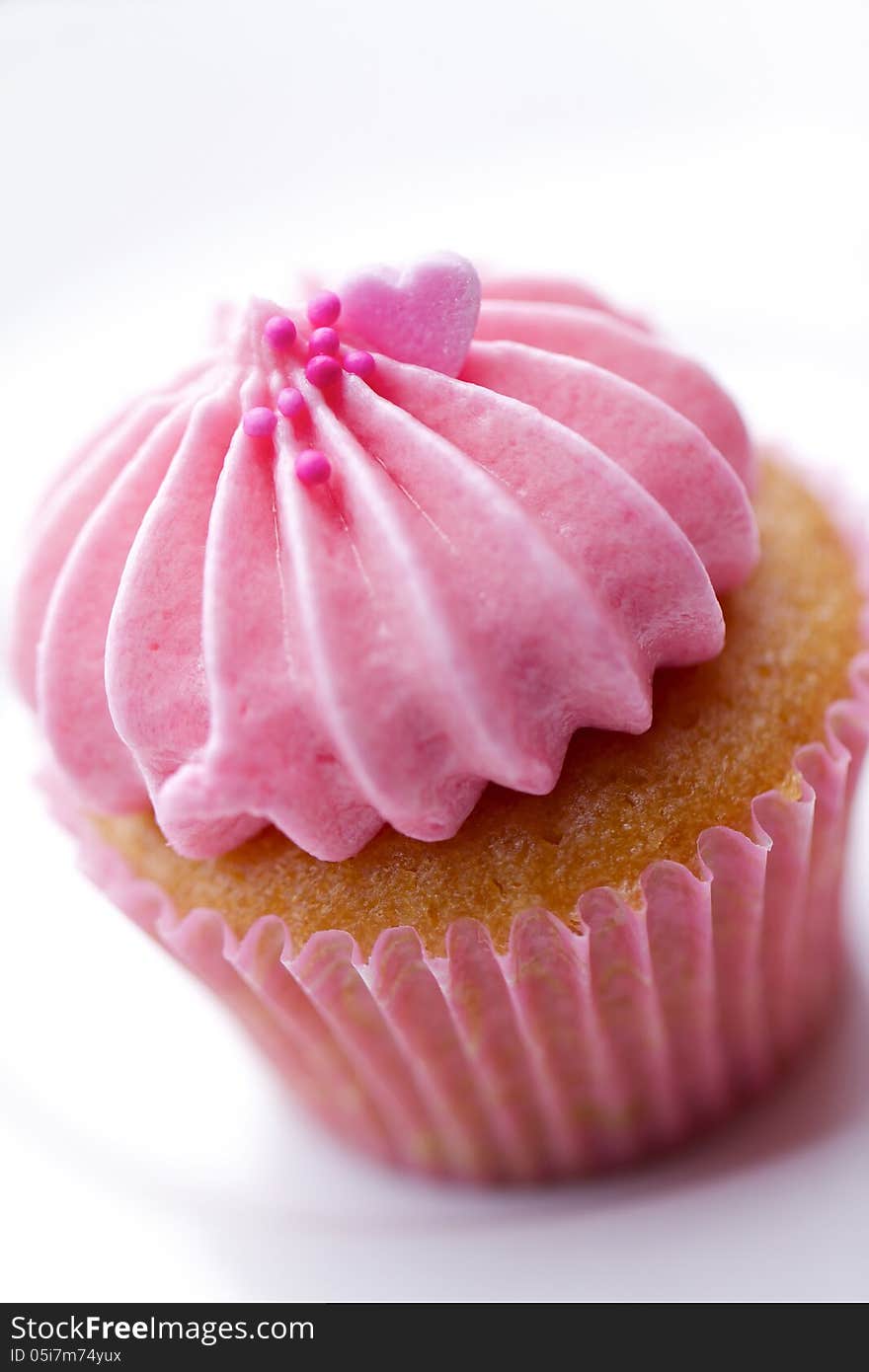 A tiny pink cupcake isolated on white background.