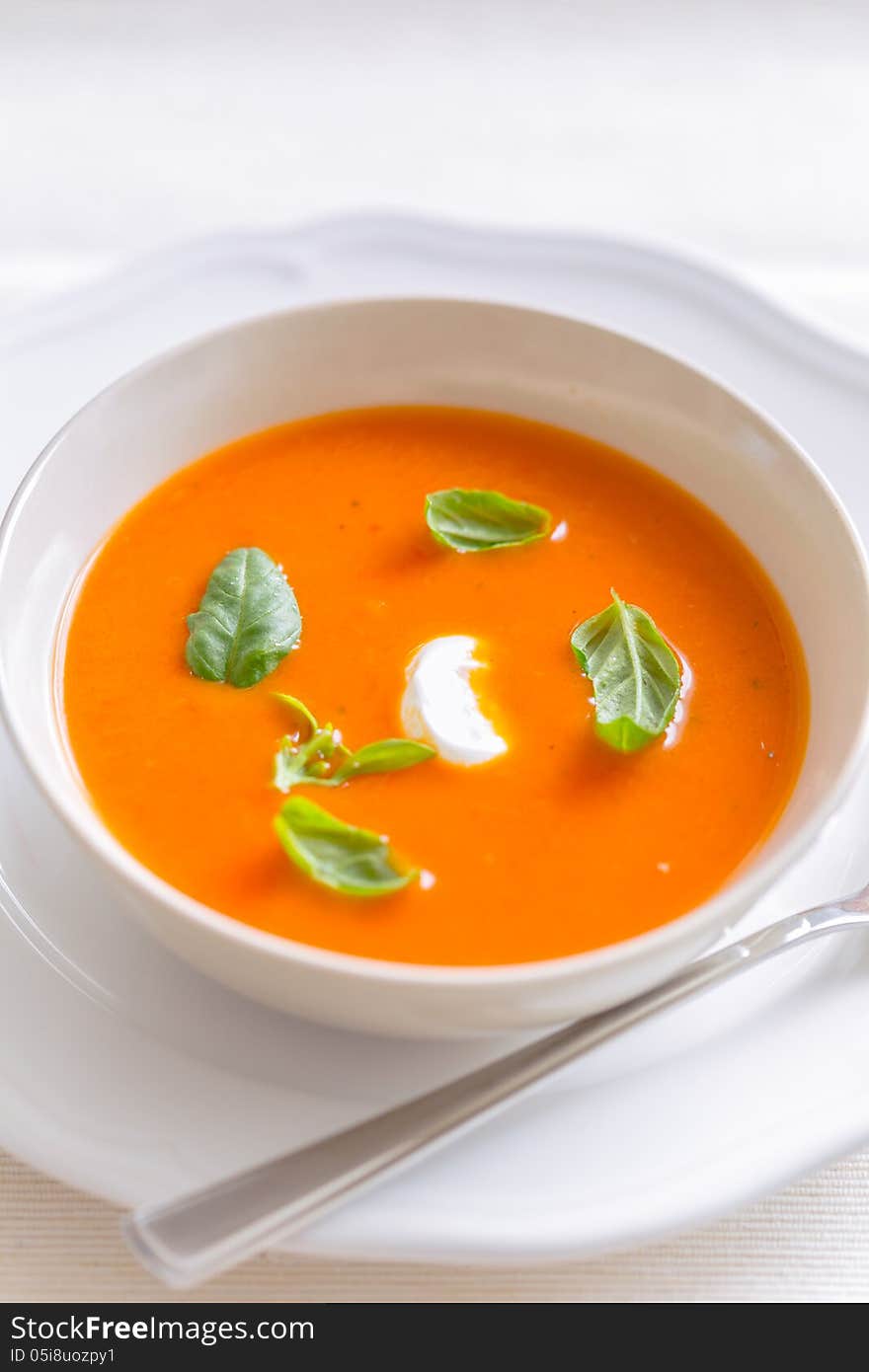 Frische tomatencremesuppe garniert mit basilikum in einer schüssel. Frische tomatencremesuppe garniert mit basilikum in einer schüssel