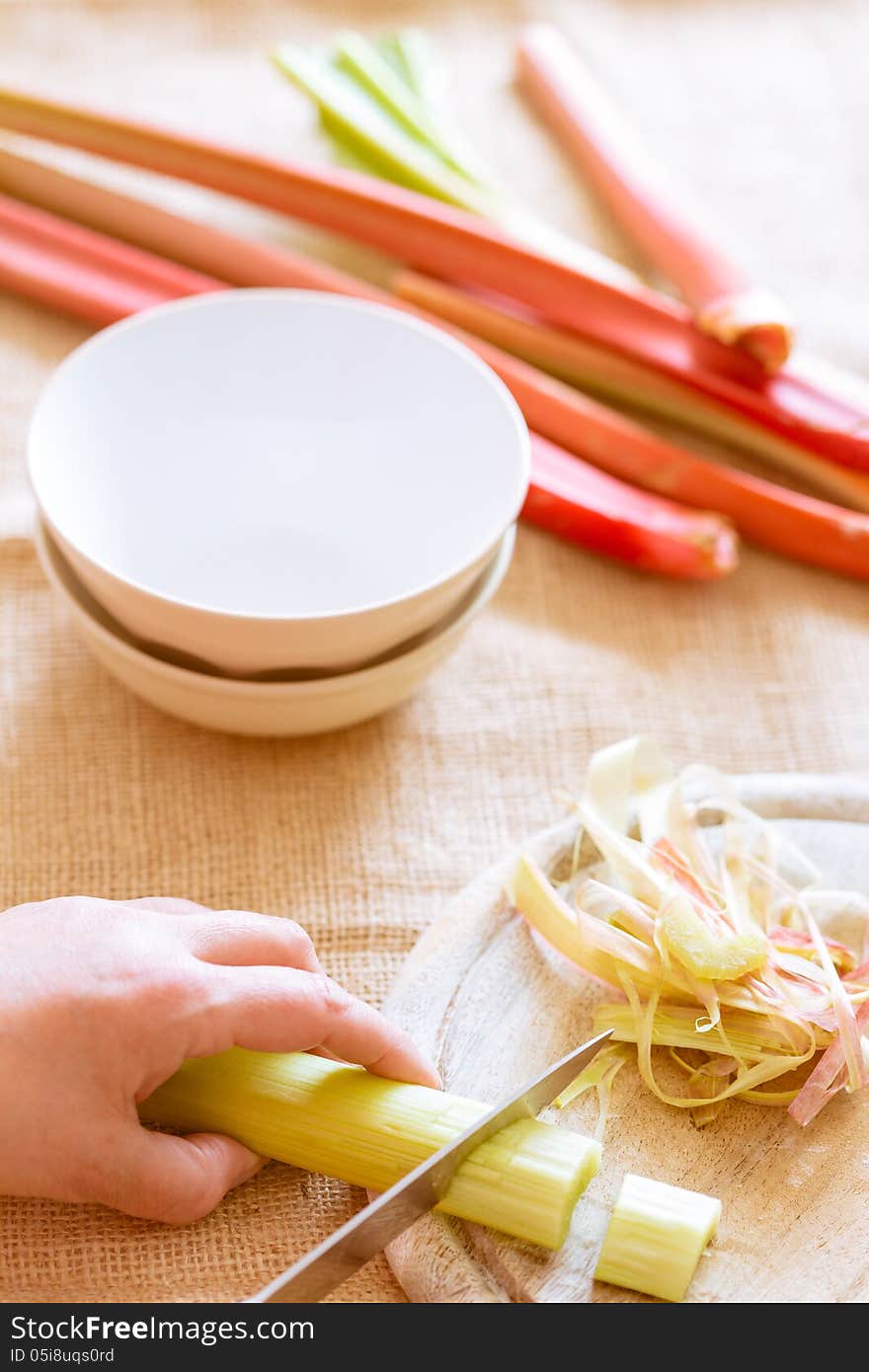 Cut of fresh rhubarb to cook a dessert. Cut of fresh rhubarb to cook a dessert