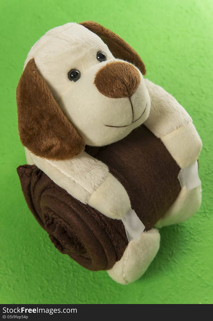 Dog doll hug brown blanket in the green background