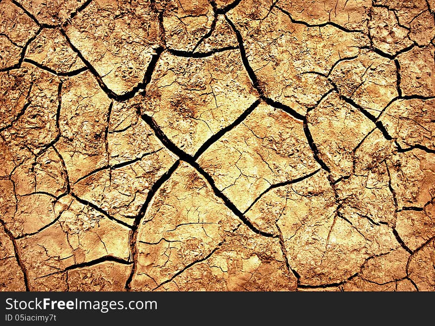 The cracks on the parched earth at the bottom of the dried-up lake