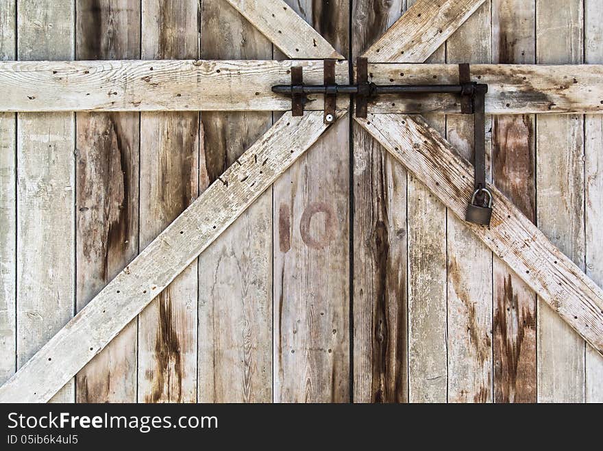 Old wooden door close by an old rusty lock. Old wooden door close by an old rusty lock