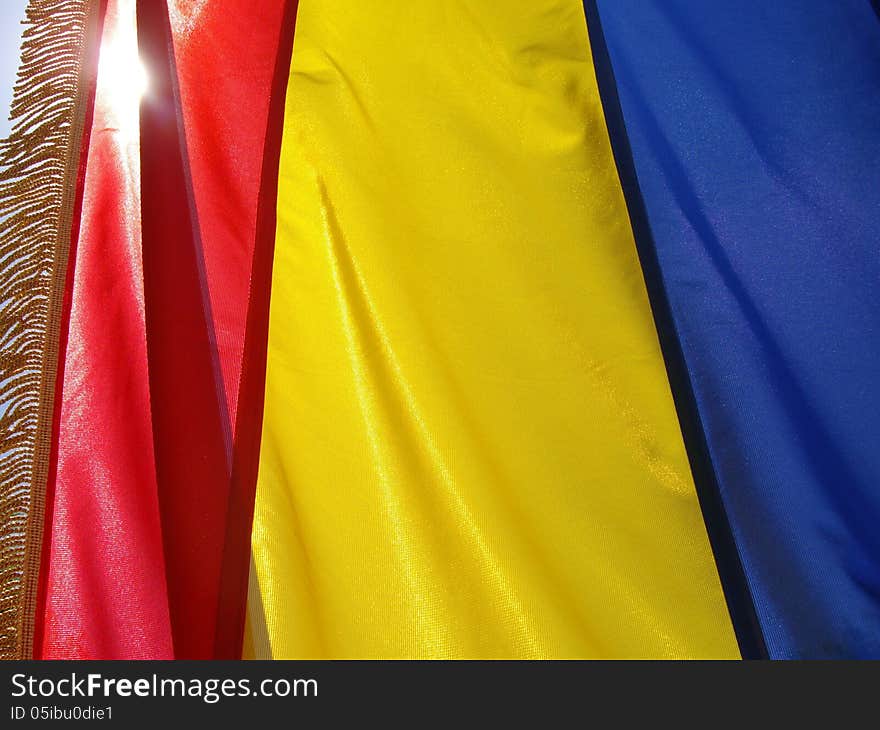 Flag of Romania waving and illuminated by sunlight