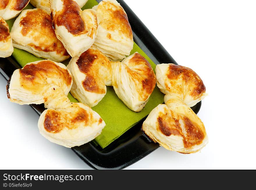 Arrangement of Fluffy Puff Pastry Bakery Bows on Green Napkin and Black Plate closeup