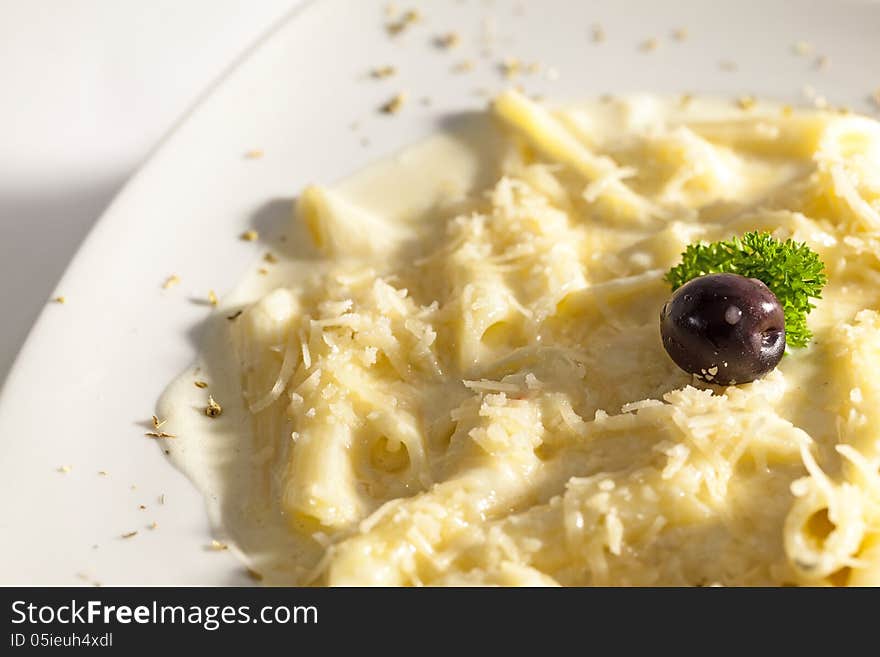 Macaroni with milk soft and cheese decorated with olives.