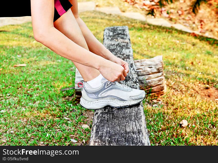 Young woman tying her shoe. Young woman tying her shoe