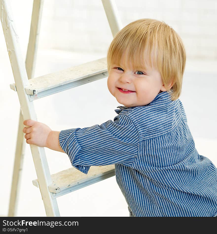 Happy little boy climbing the ladder