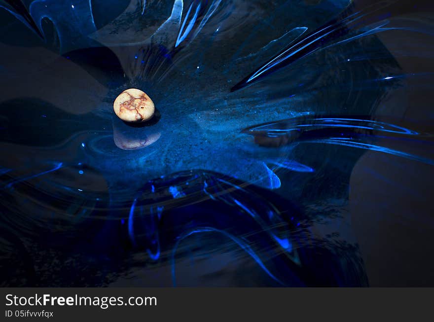 Colored pebble on a blue glass surface