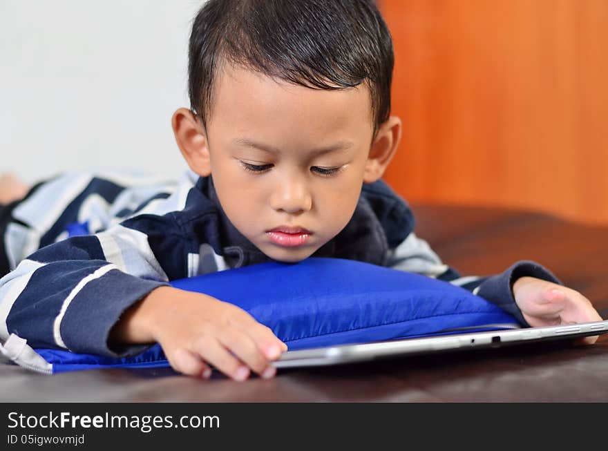 A boy playing a game on computer tablet