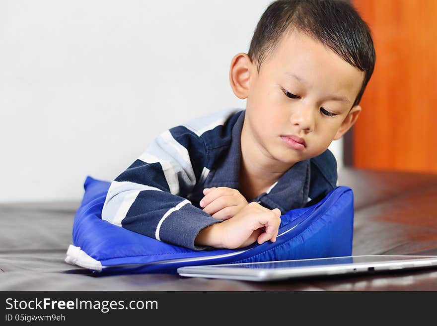 Close up a boy playing a game on computer tablet