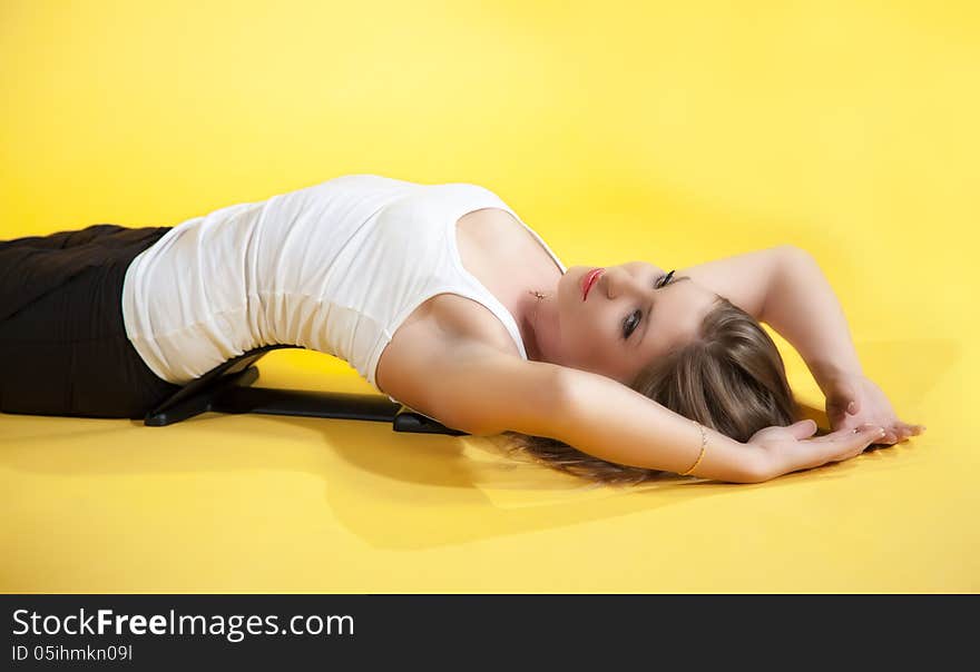 Young woman is engaged in a sports trainer onyellow background