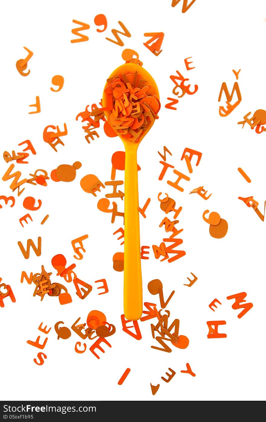 Yellow spoon and orange alphabet on a white background