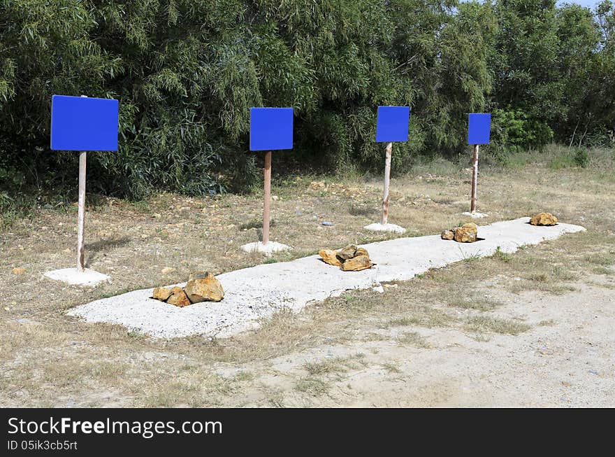 Four blue signs indicate danger with stones placed side.